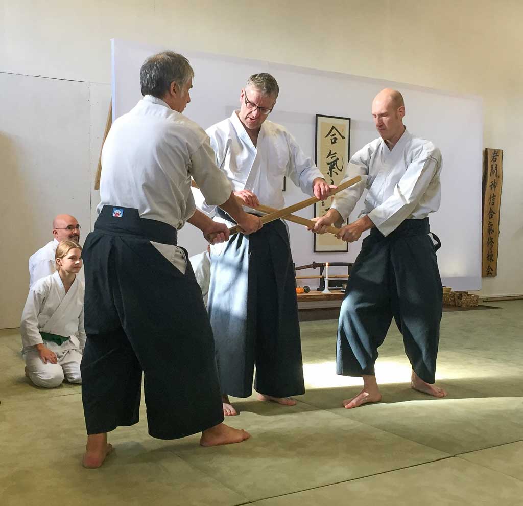 Ein Aikidoka im Hakama wehrt den Schwertangriff eines anderen Aikidoka ab.